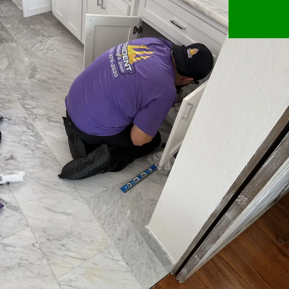Plumber working on kitchen faucet