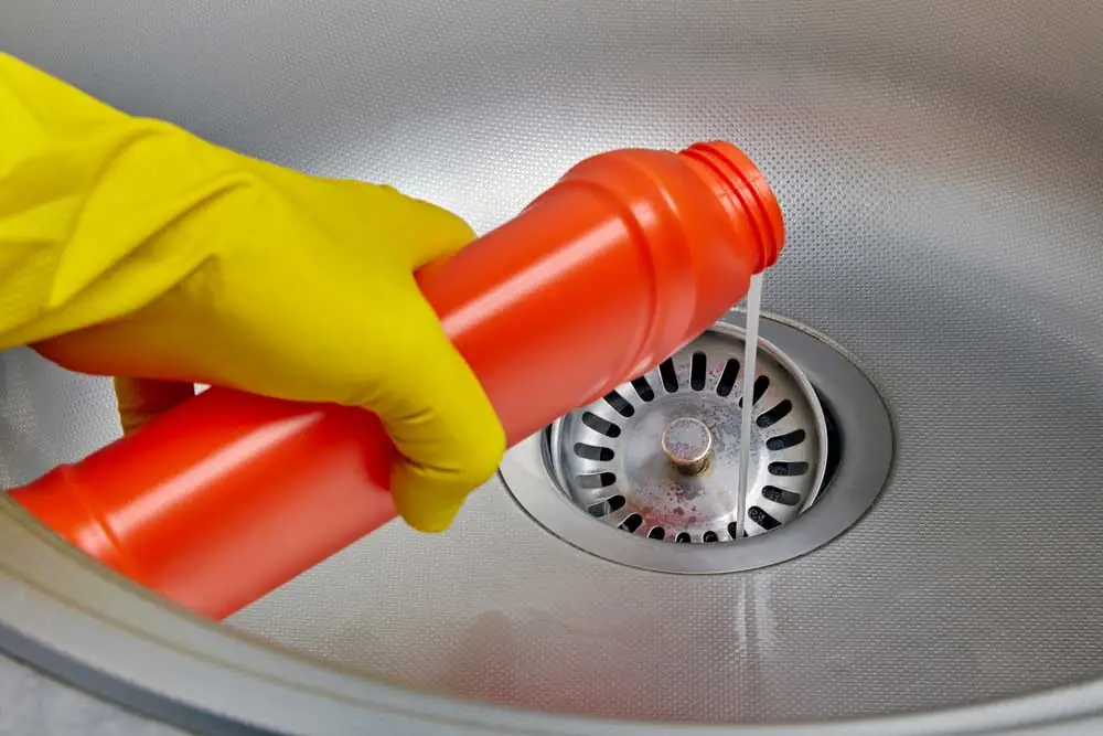 a frustrated person holding a bottle of drain cleaning solution