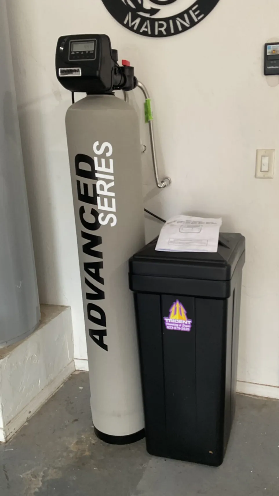 An Advanced Series water treatment tank and brine tank on a garage floor
