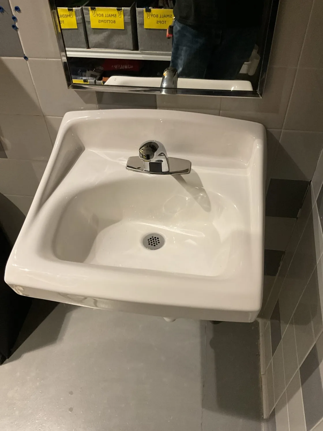 A wall-mounted commercial sink and faucet