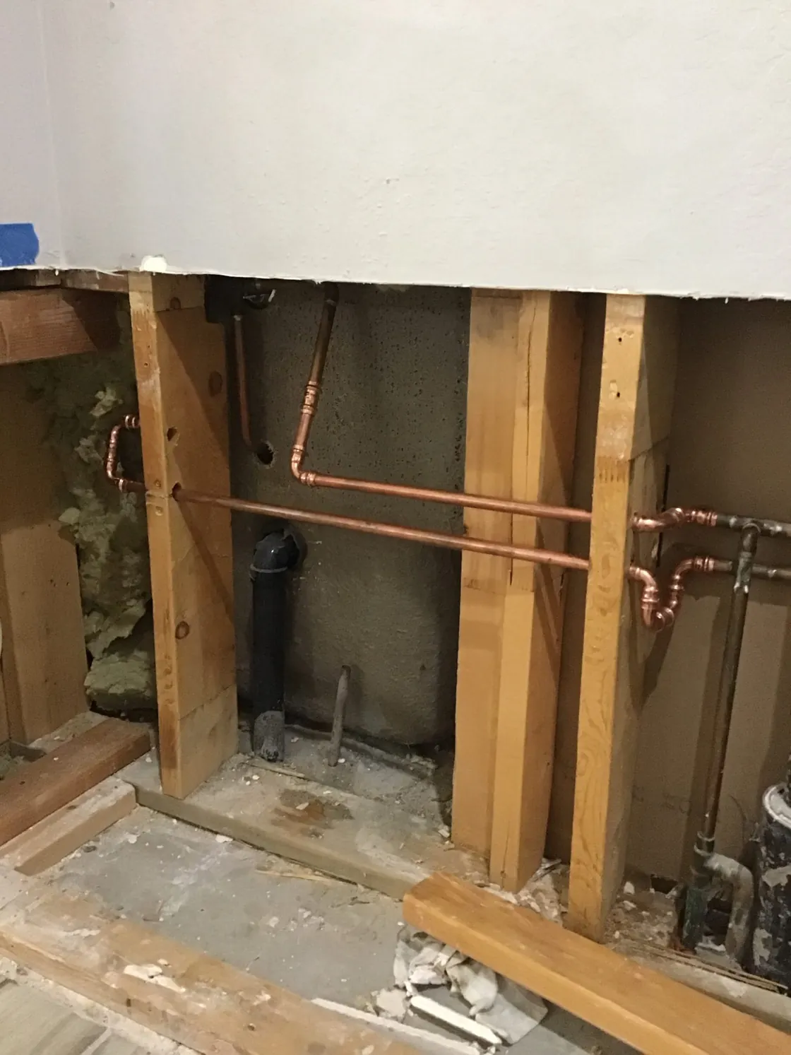 Copper supply pipes routed through exposed wall framing