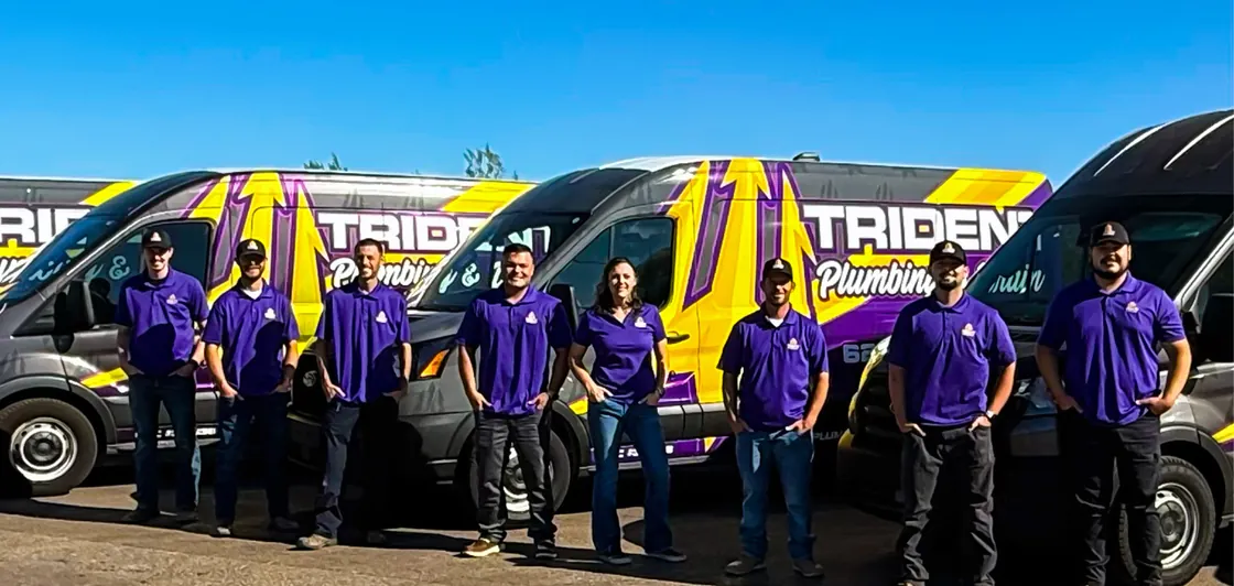 Trident team members standing together in front of their service vans