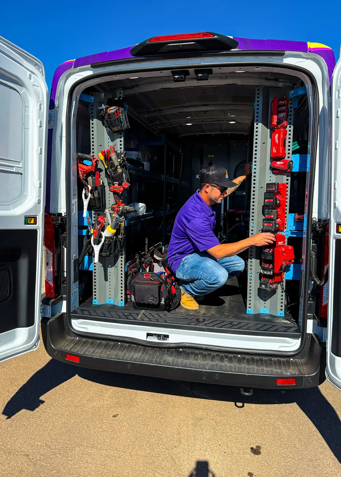 A Trident technician organizing equipment in a stocked service van