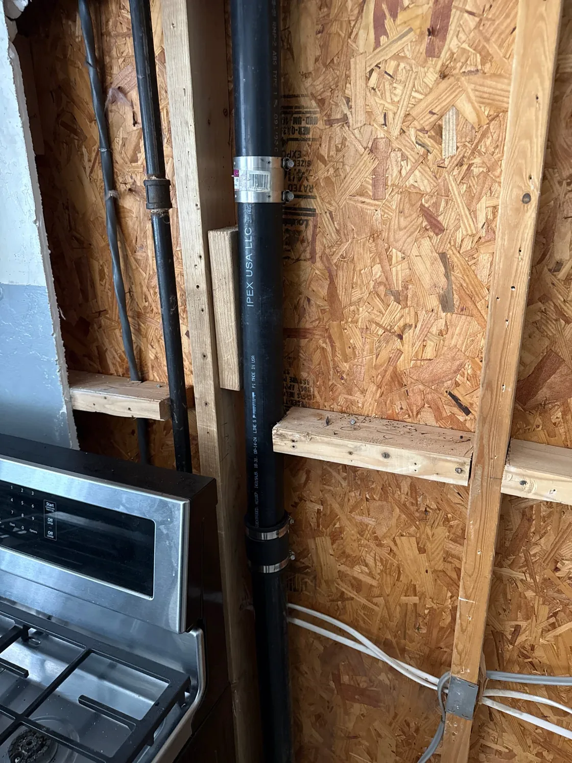Repaired drain pipe inside an opened wall