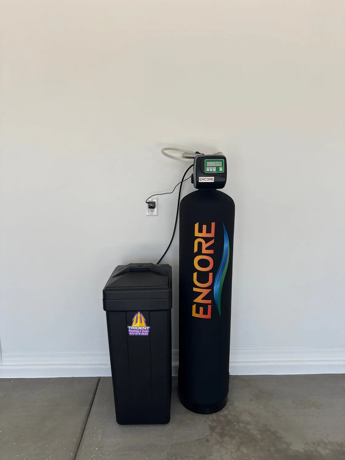 An Encore water treatment tank standing beside its black brine tank