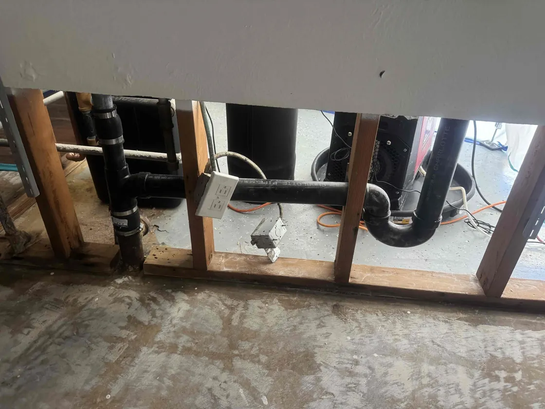 Black drain pipes exposed behind an opened wall
