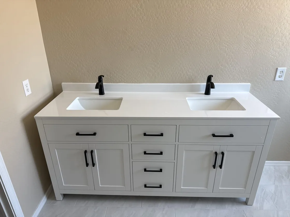 A double bathroom vanity with two black faucets