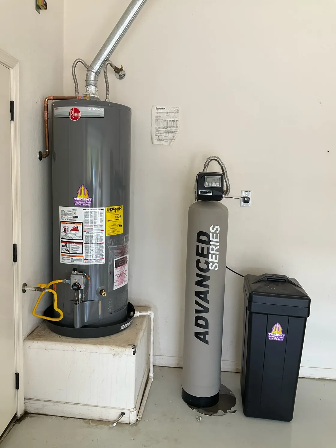 A gas tank water heater on a raised platform beside an Advanced Series treatment tank