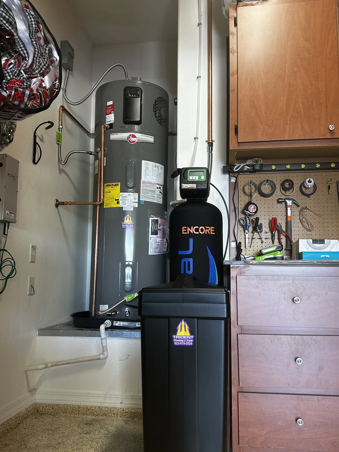 A Rheem hybrid water heater beside Encore water treatment equipment