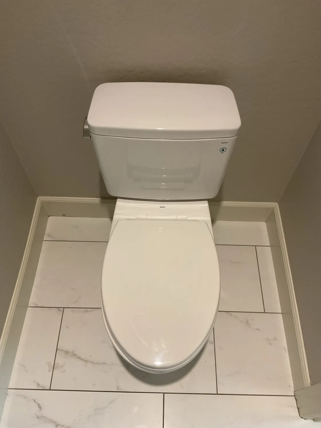 A TOTO toilet installed on a tiled bathroom floor