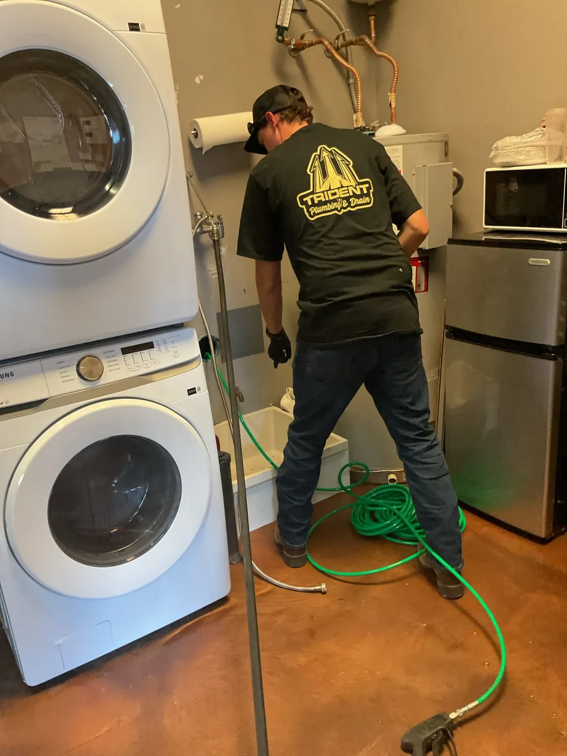 Drain-service hoses in use beside laundry appliances