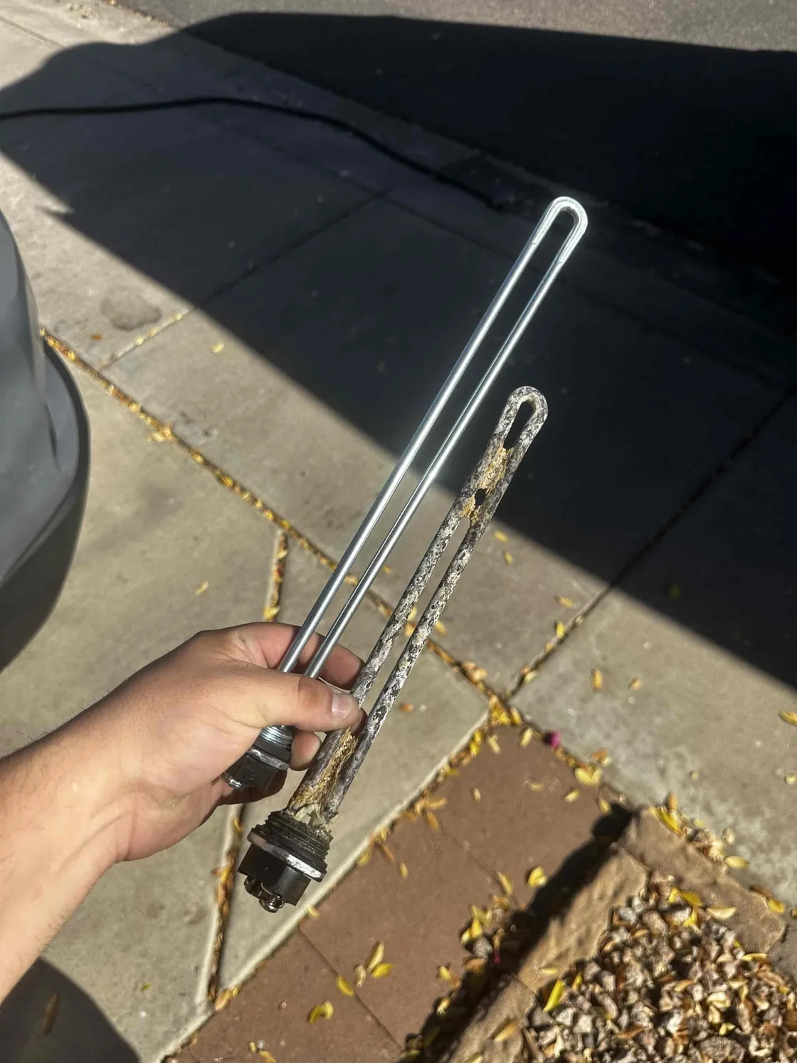 New and worn water heater anode rods held side by side