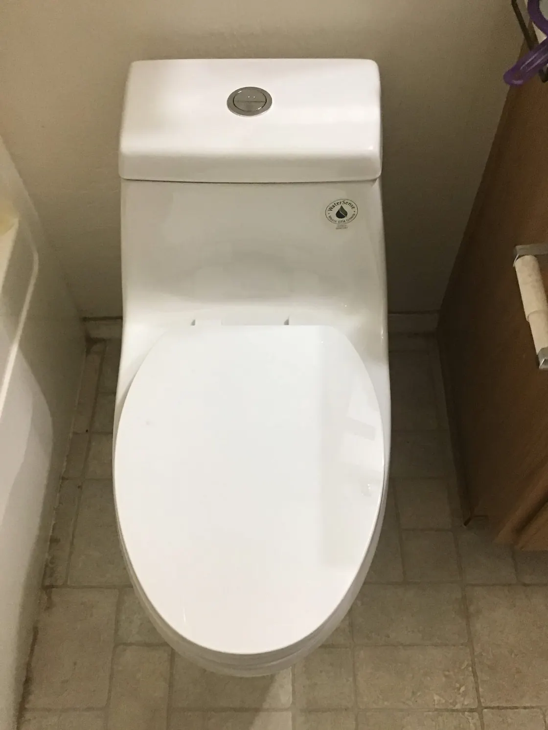 A white one-piece toilet installed on a tile floor