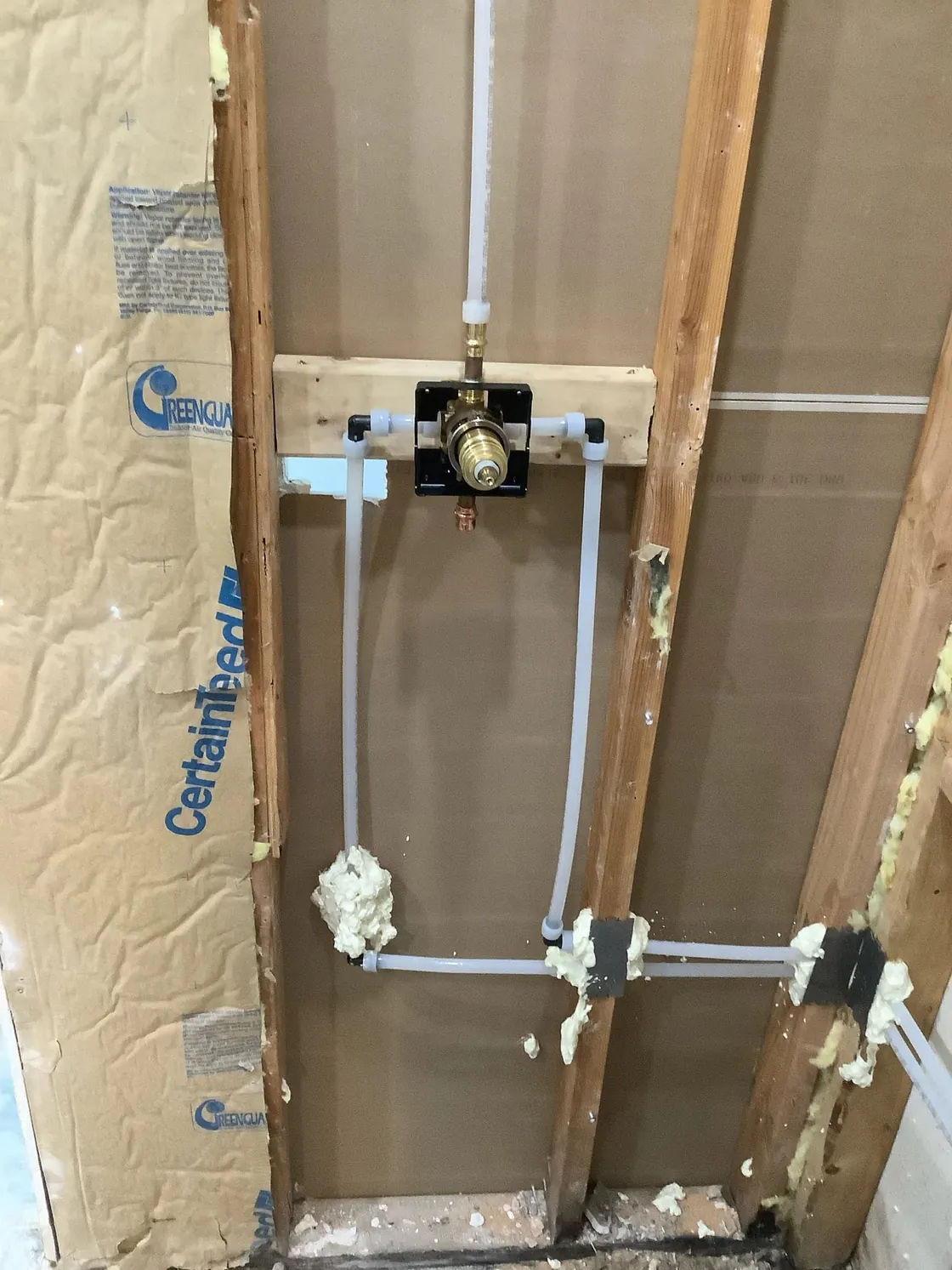 PEX supply lines and a shower valve installed in open wall framing