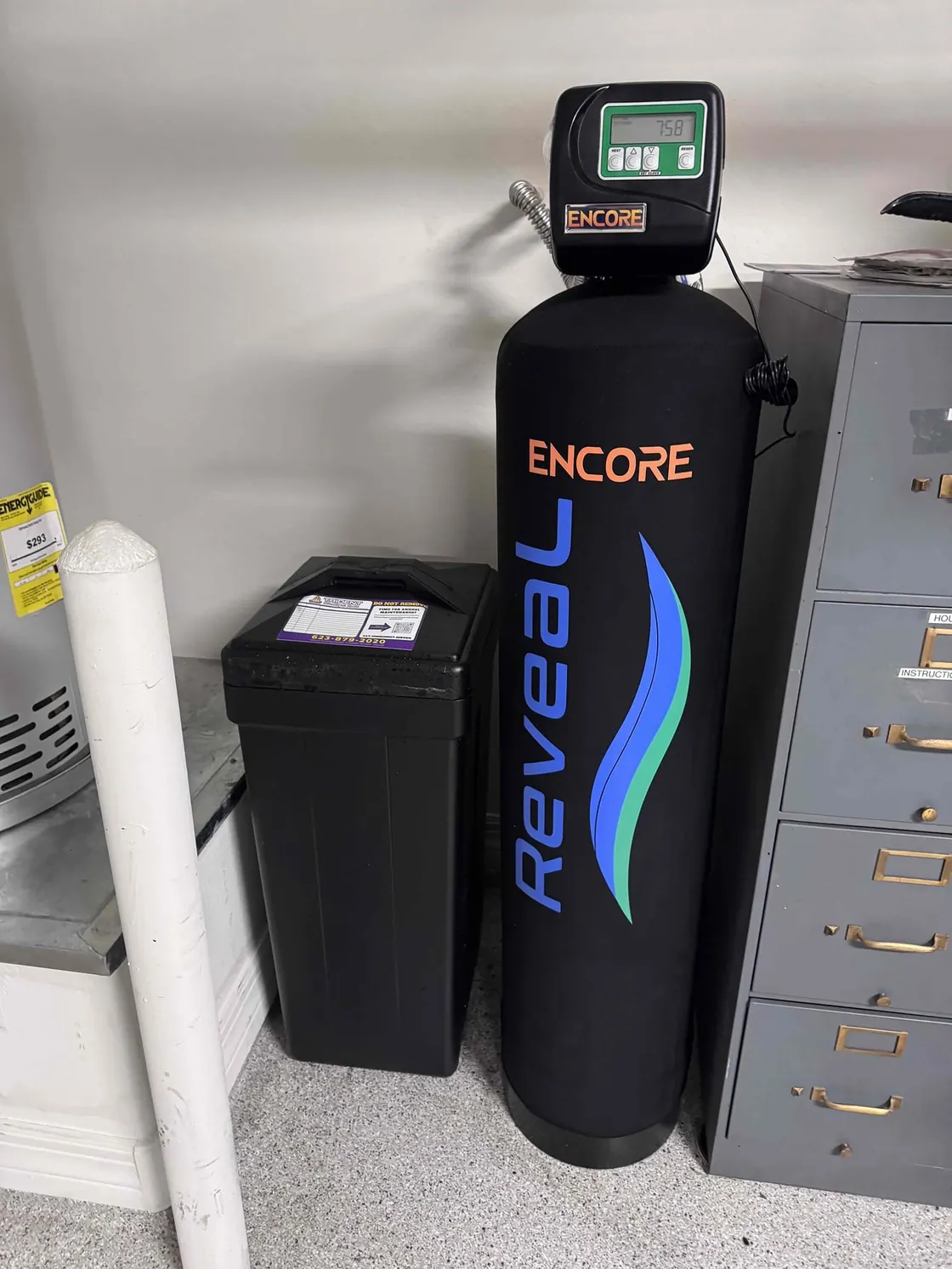 An Encore Reveal water treatment tank and brine tank in a garage