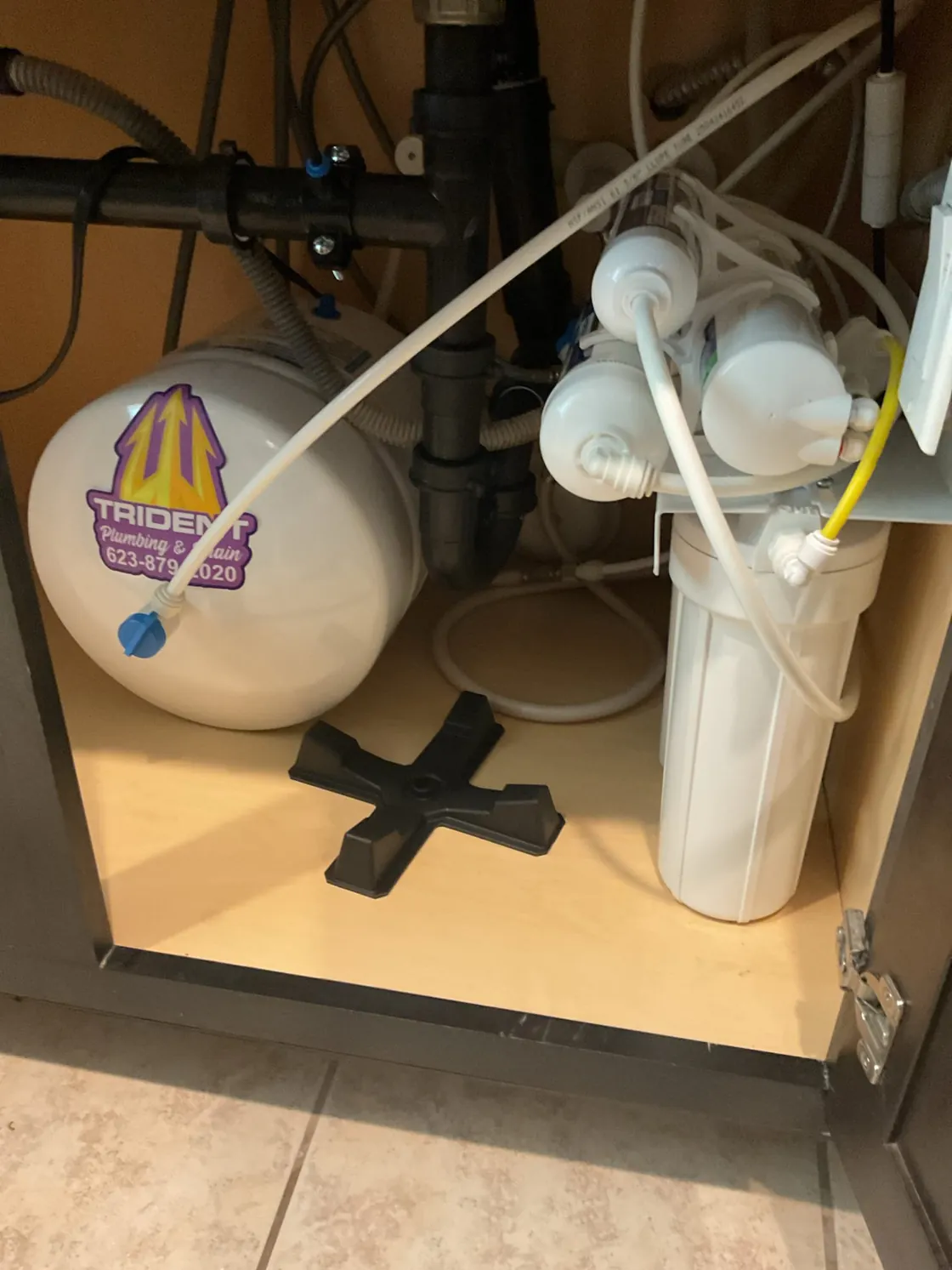A reverse osmosis system with its storage tank and filter housings in a kitchen sink cabinet