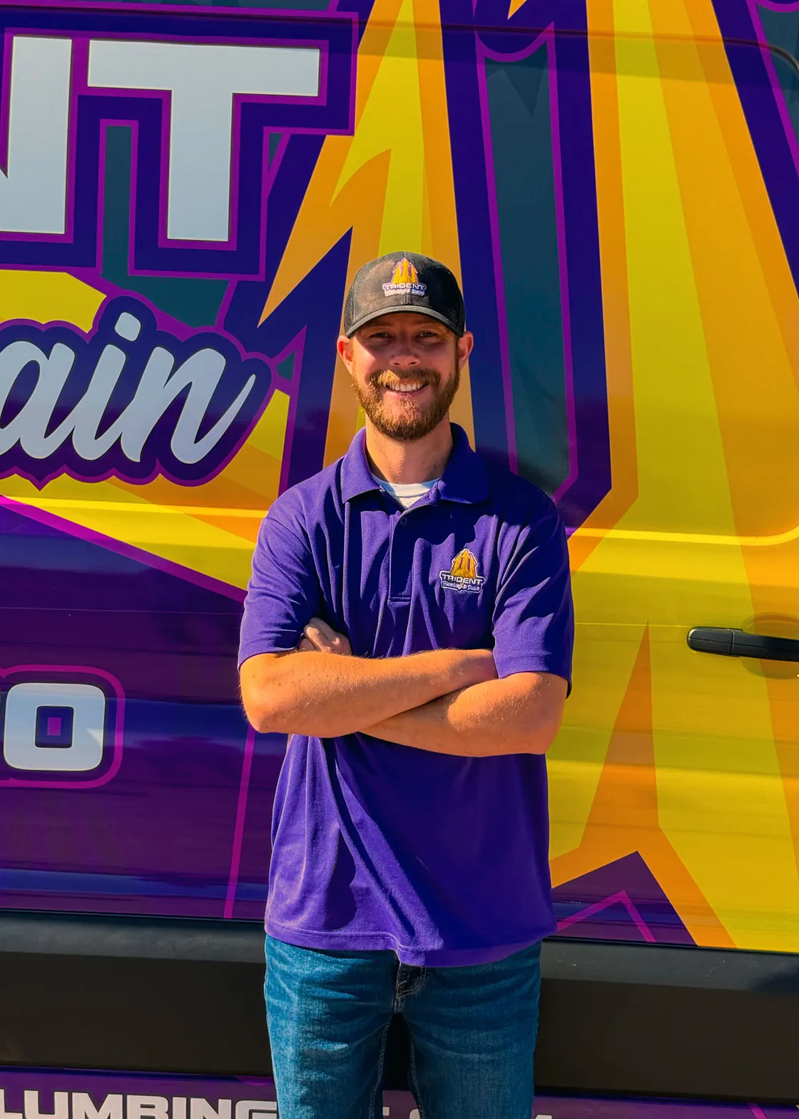 A Trident team member wearing a purple shirt and cap