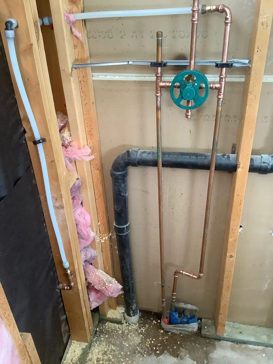 Shower valve and pipe connections exposed inside an open wall