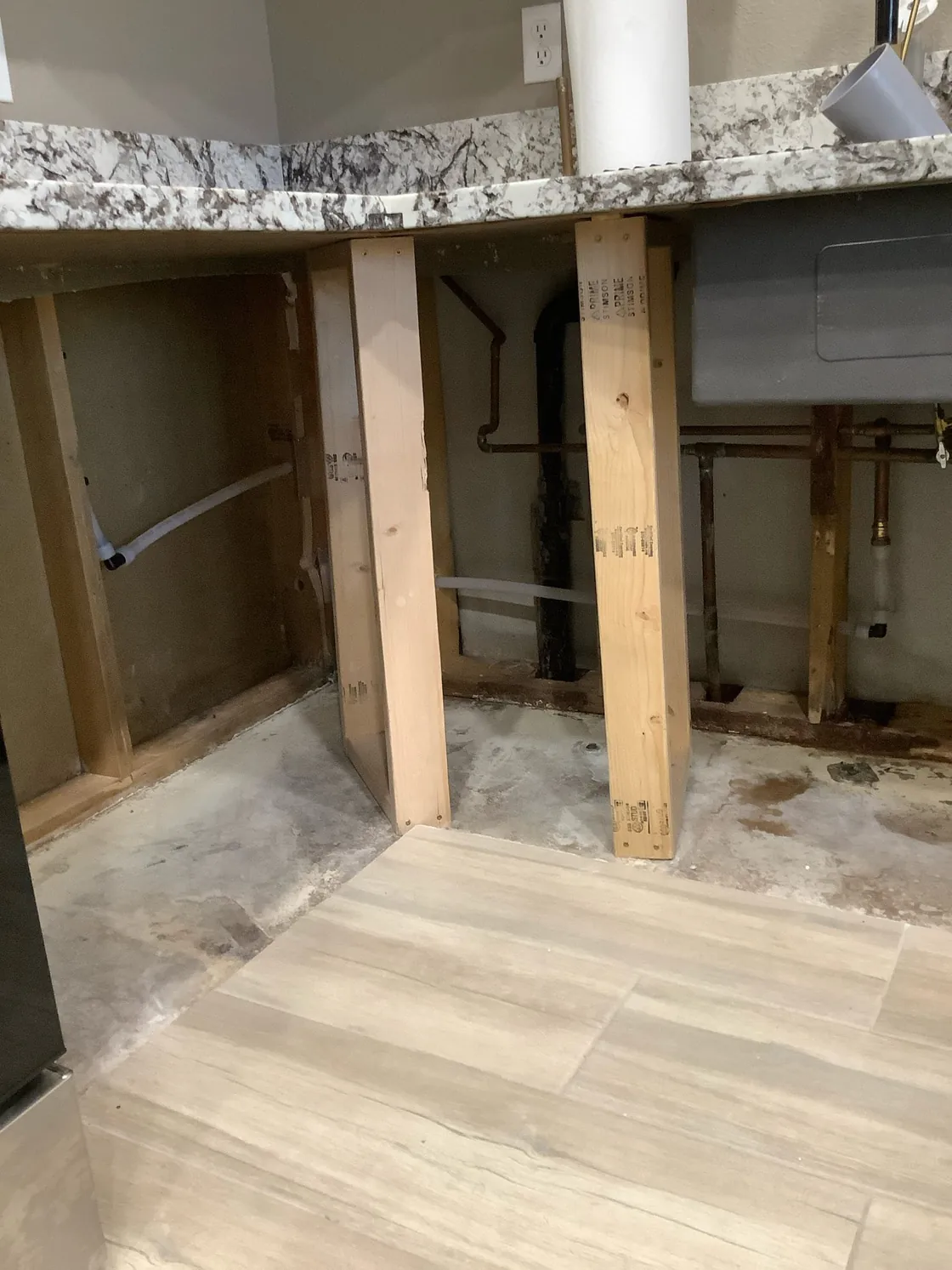 Rerouted plumbing visible inside an opened wall