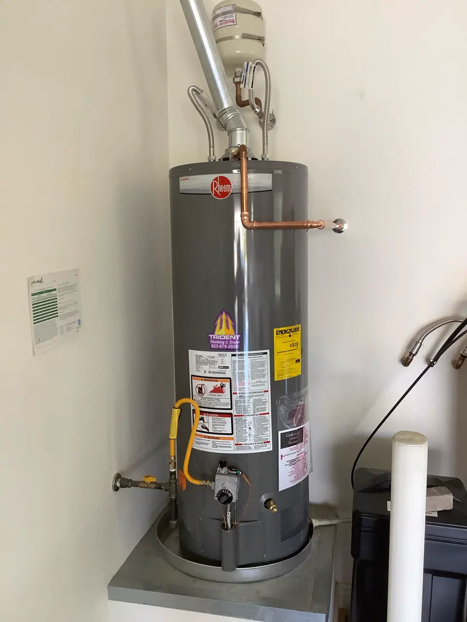 Installed tank water heater with an expansion tank and connected pipework