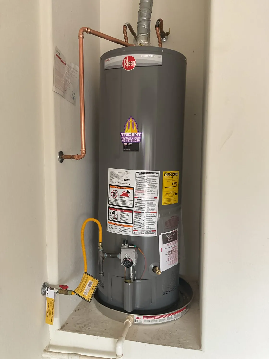 A tank water heater and its connections installed in a utility space