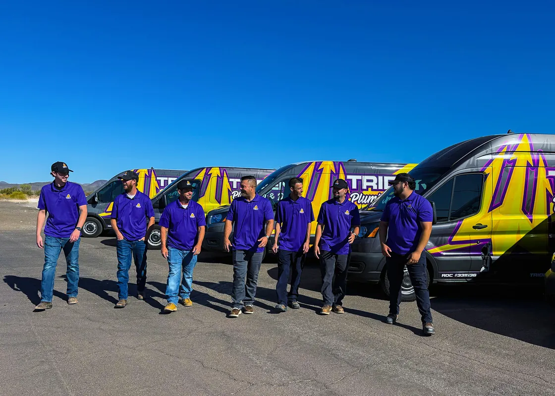 Trident team members walking beside a row of purple and gold service vans