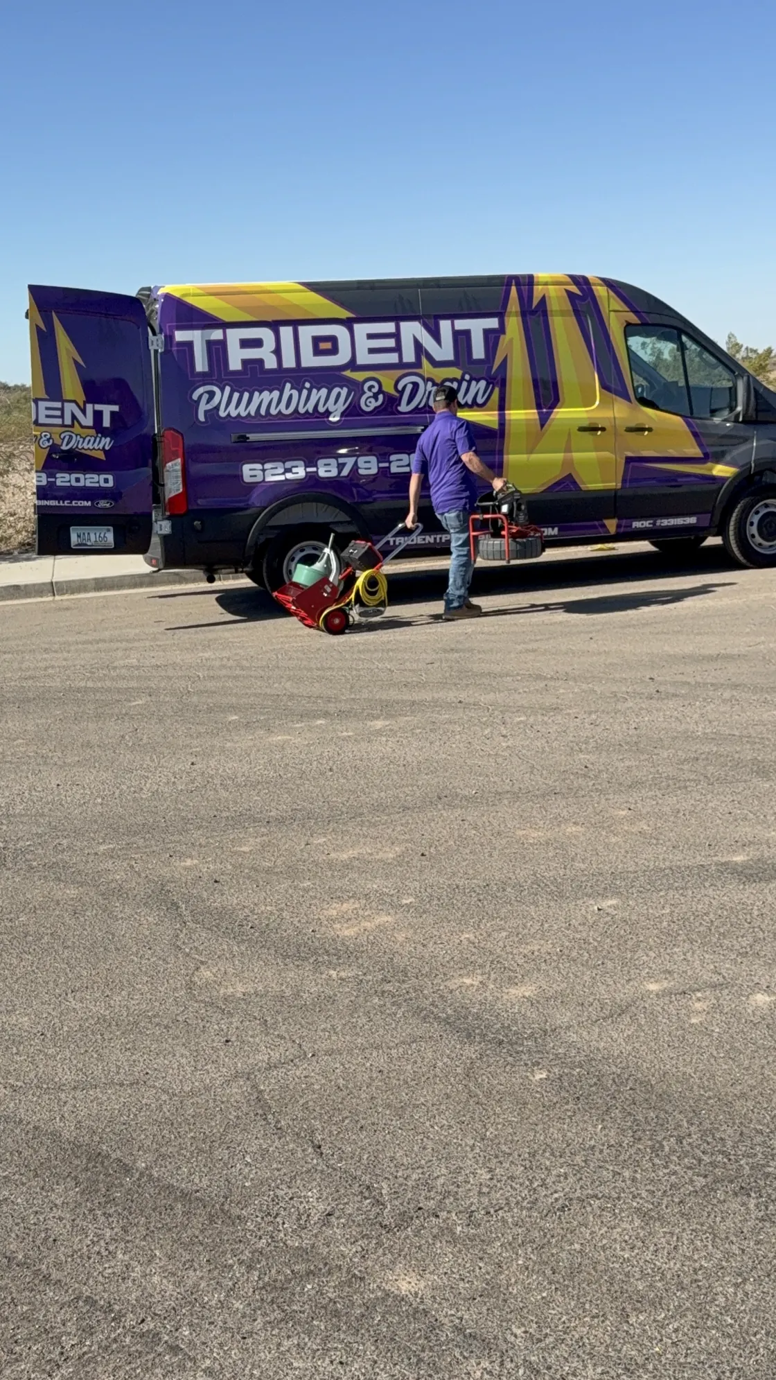 A Trident technician with tools beside a service van