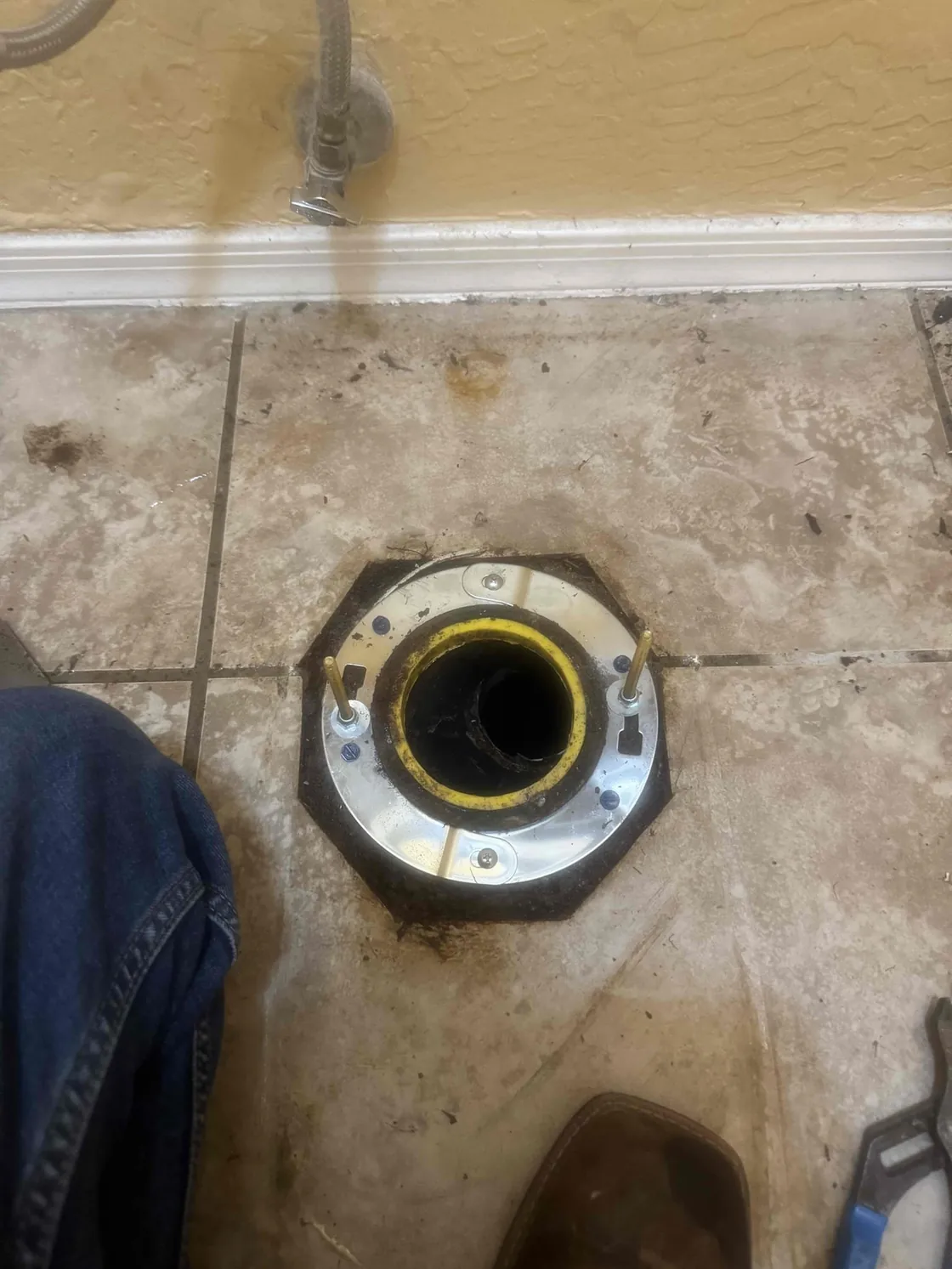 A repaired toilet flange visible with the toilet removed