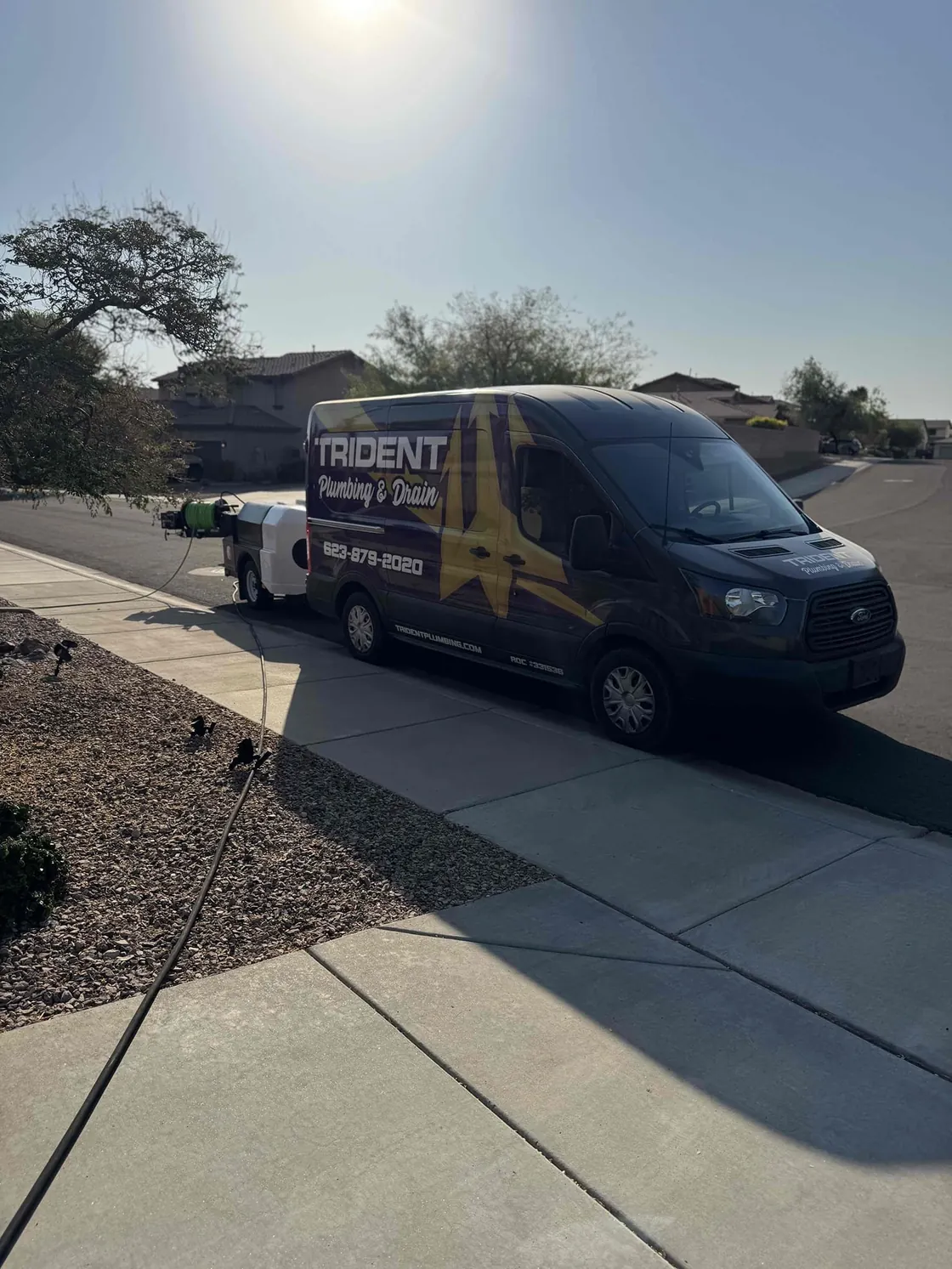 A Trident van parked at a curb on a sunny residential street