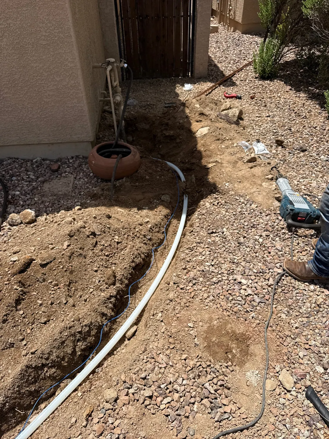 A trench running along a side walkway with a white line laid in it