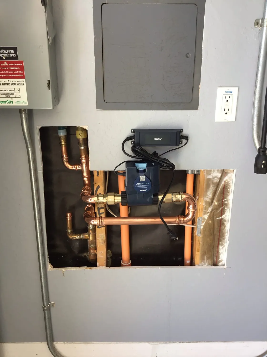 A water monitoring device connected to copper pipes in an opened wall