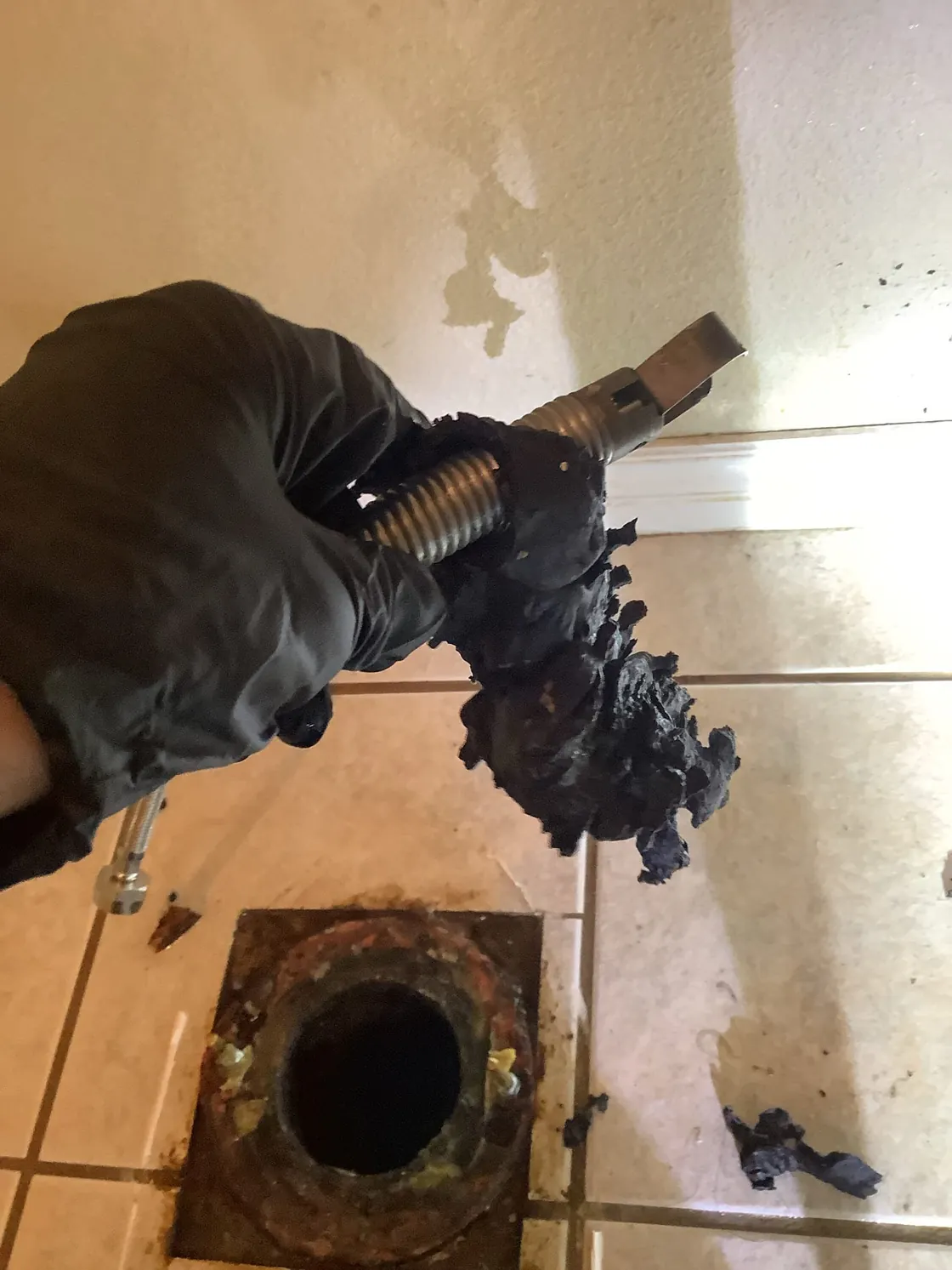 Removed wipes held above an exposed toilet connection