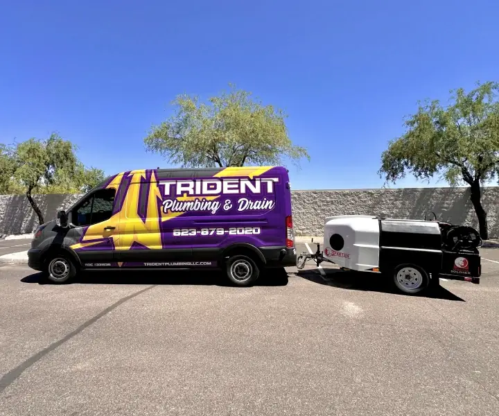 A Trident service van and hydro jetting trailer on an Arizona street