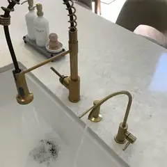 Gold kitchen faucet with a matching drinking-water faucet