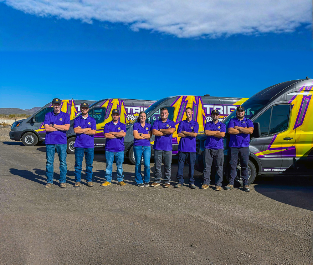 Trident Plumbing Team standing in front of service vehicle fleet