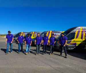 Trident plumbing team walking infront of their service fleet, talking and walking