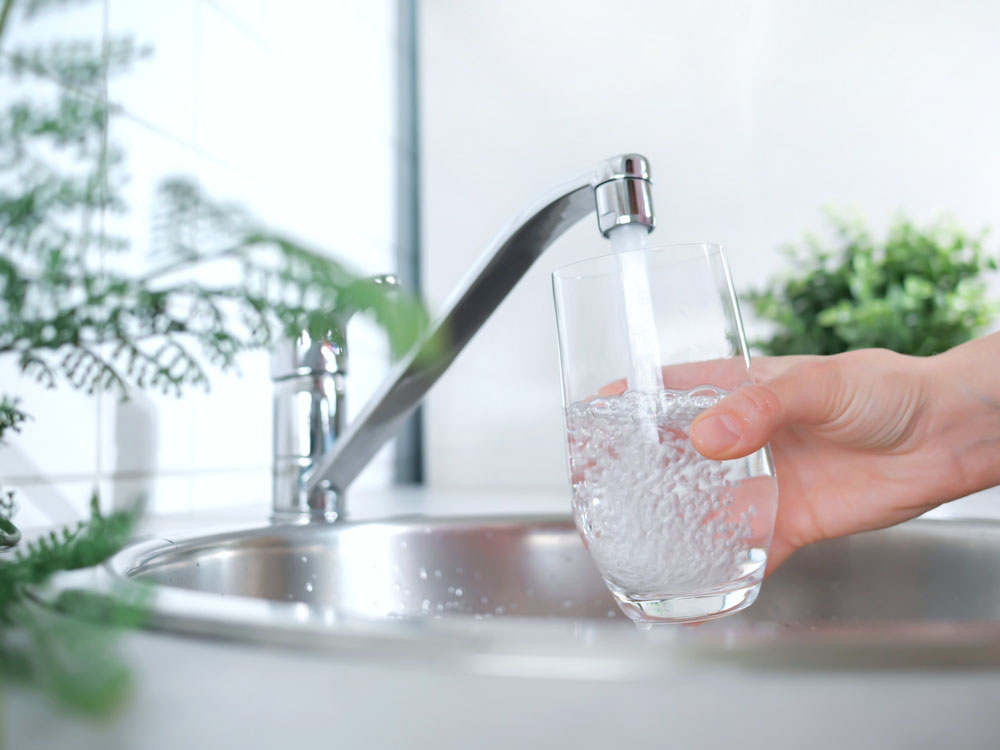 drinking glass under a running tap