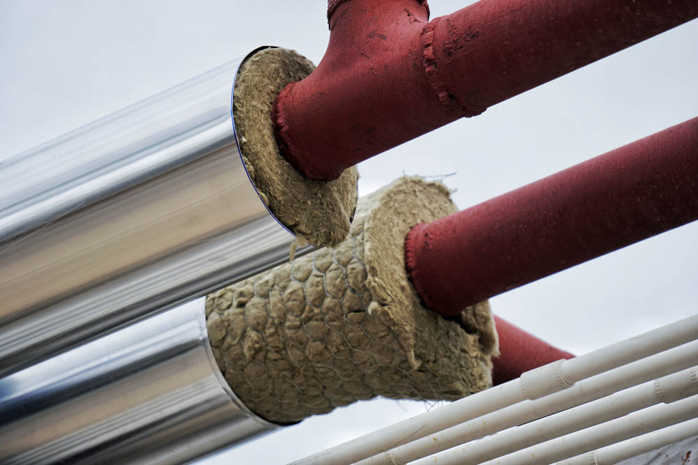 Trident technician insulating a water heating system