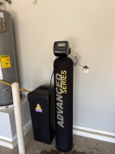 Professional installation of a whole home water softener system in a Phoenix garage.