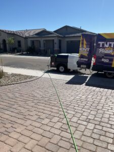 A high-pressure hydro-jetting machine hooked up and ready for sewer line cleaning at a residential job site.