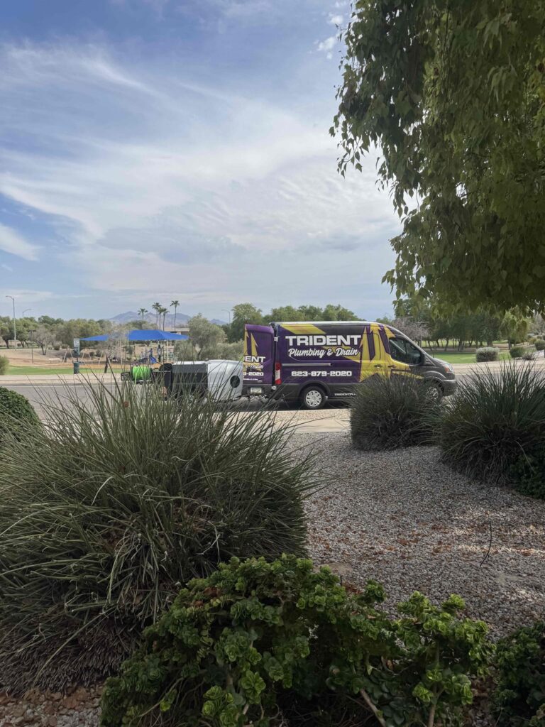 A Trident Plumbing service van parked in a residential driveway in front of a modern West Valley home.