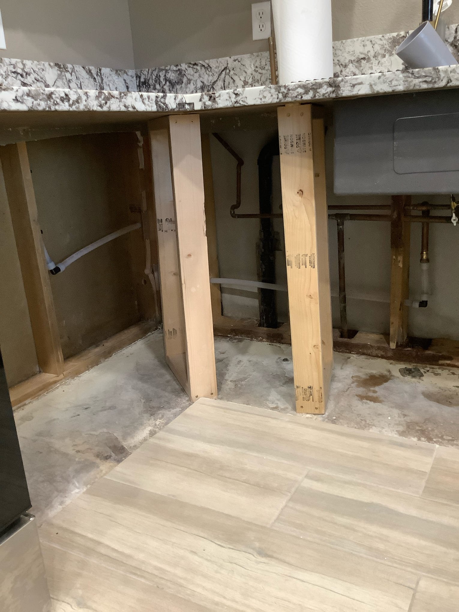 Exposed kitchen plumbing during water leak detection and water line repair in an Arizona home
