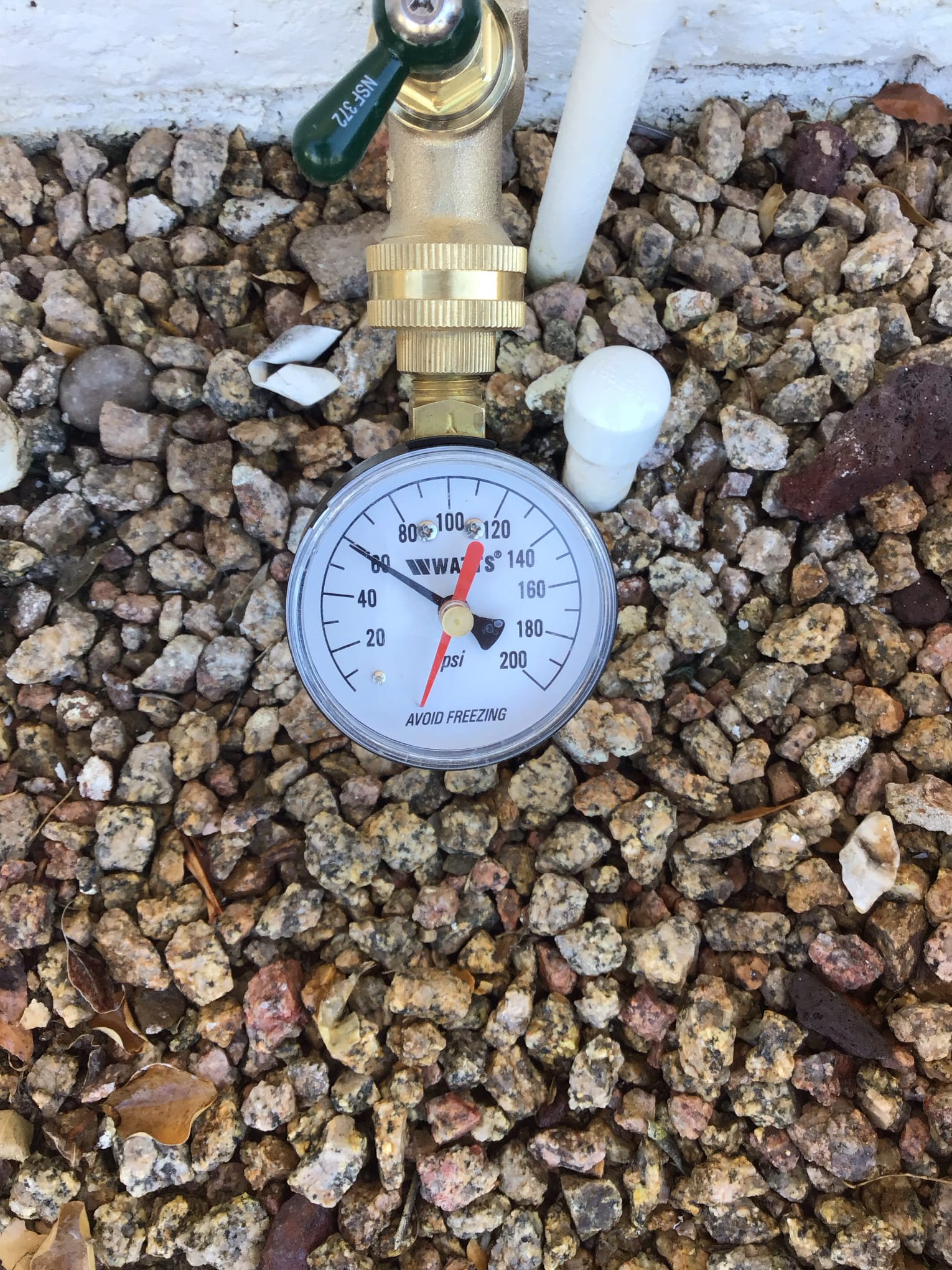 Water pressure gauge checking residential plumbing pressure in Arizona