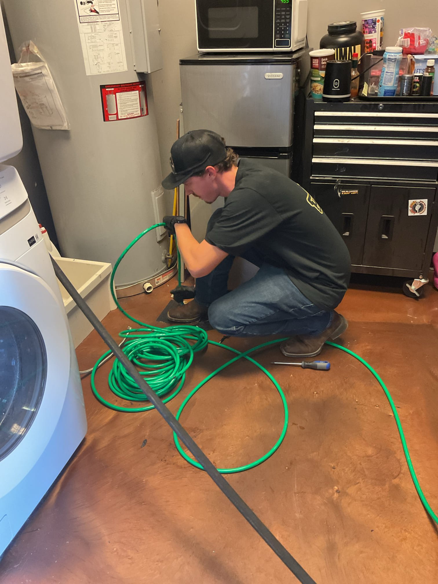 Plumber performing professional drain cleaning inside an Arizona home