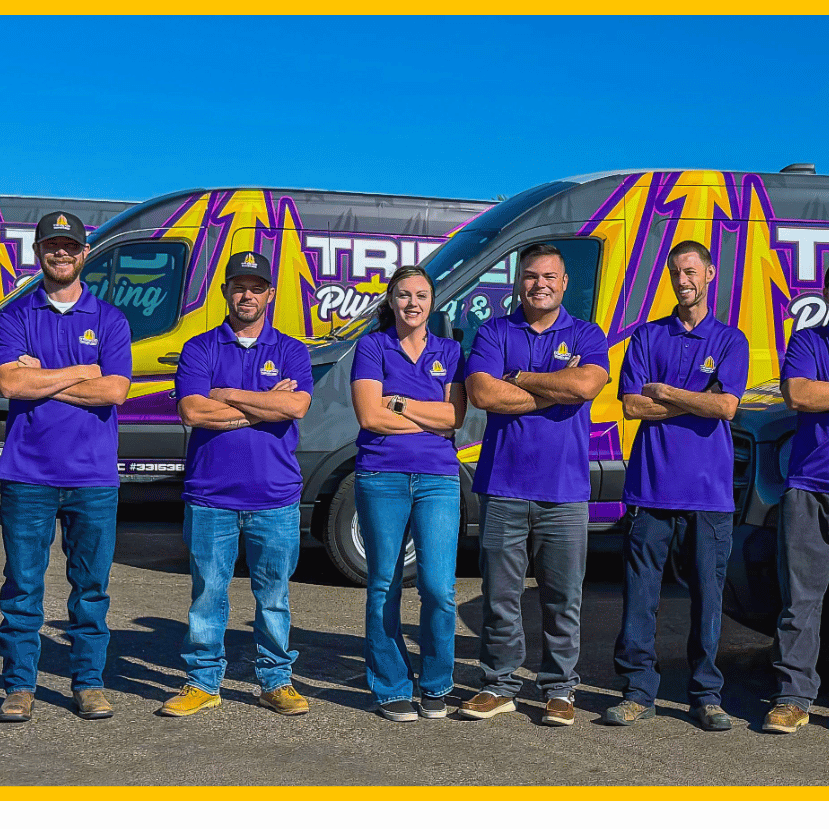 Trident Plumbing & Drain Team Photo posing infront of work trucks