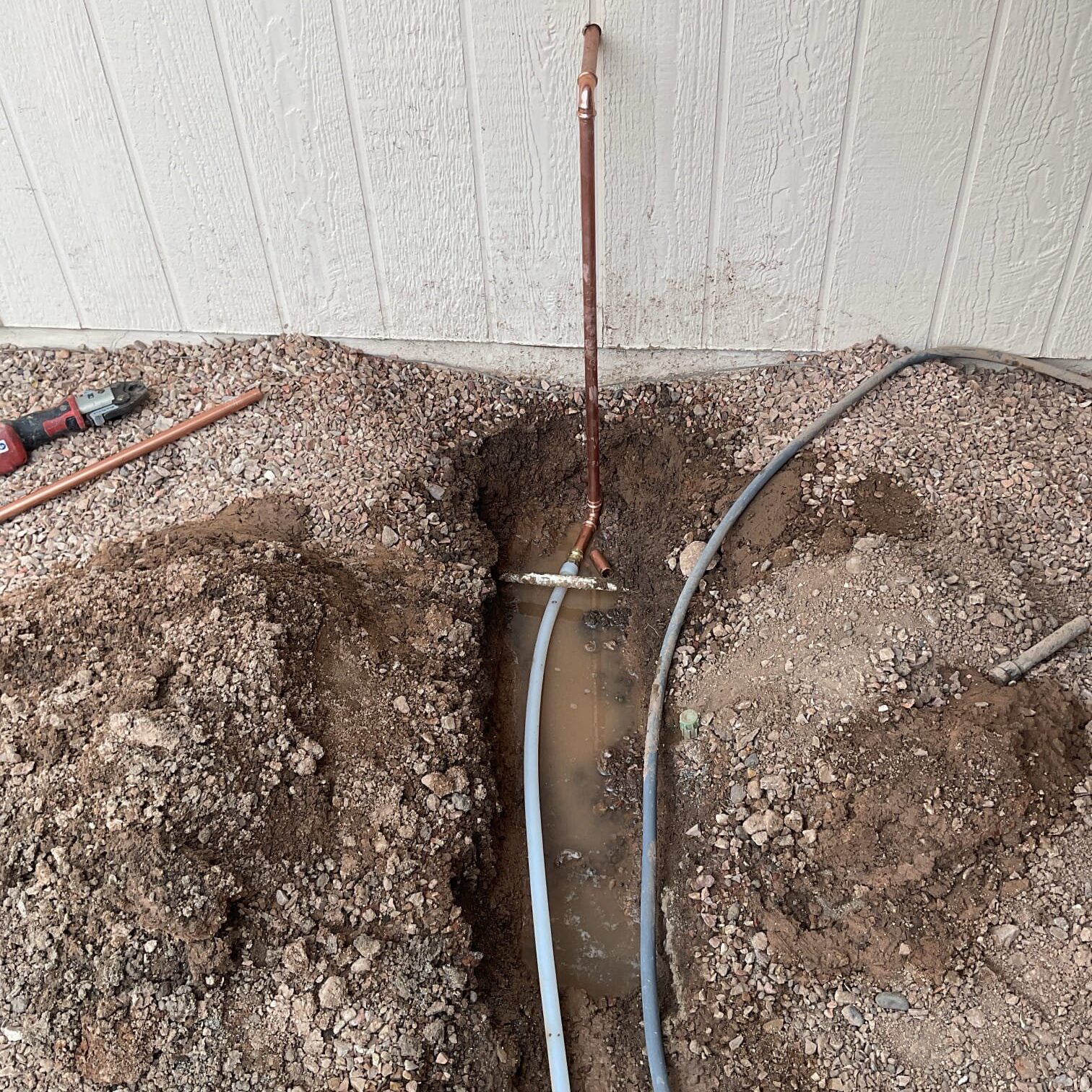 Exposed underground plumbing during hidden water leak diagnosis and pipe reroute in Arizona